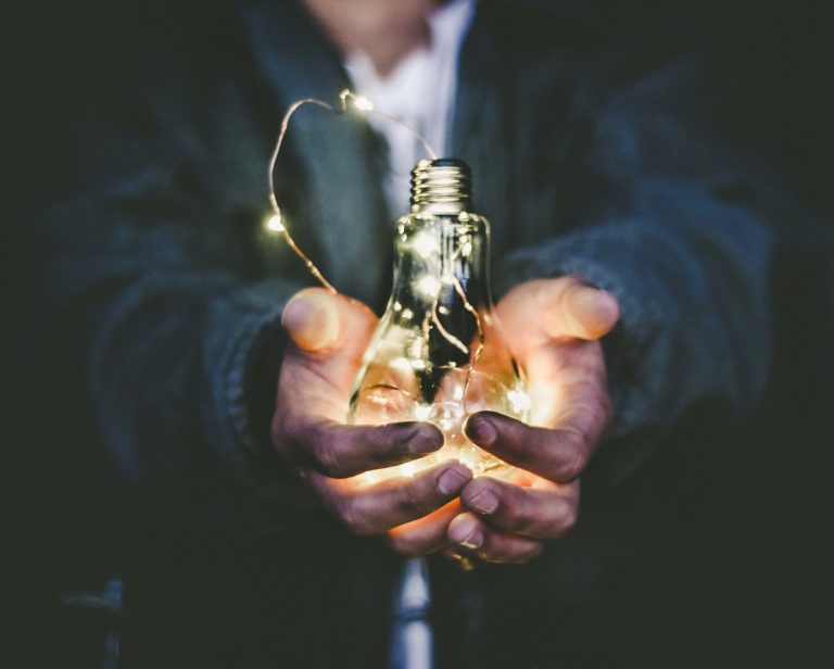 Person holding a glowing lightbulb - innovative ready-made solutions