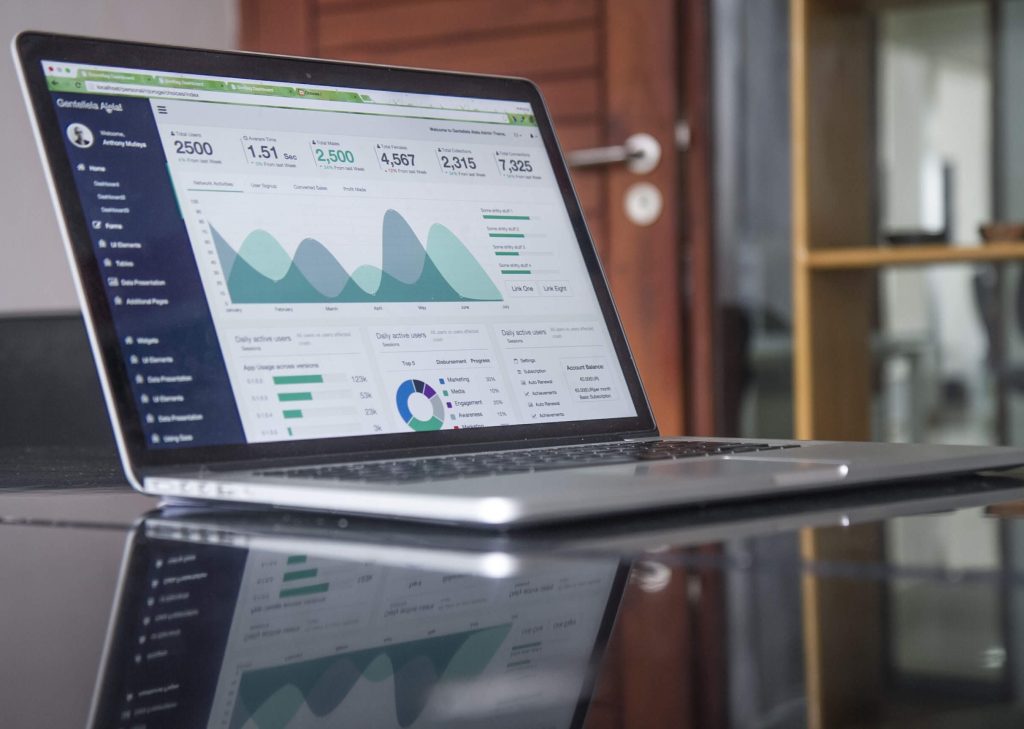 Laptop on a desk displaying a business analytics dashboard with charts and performance metrics